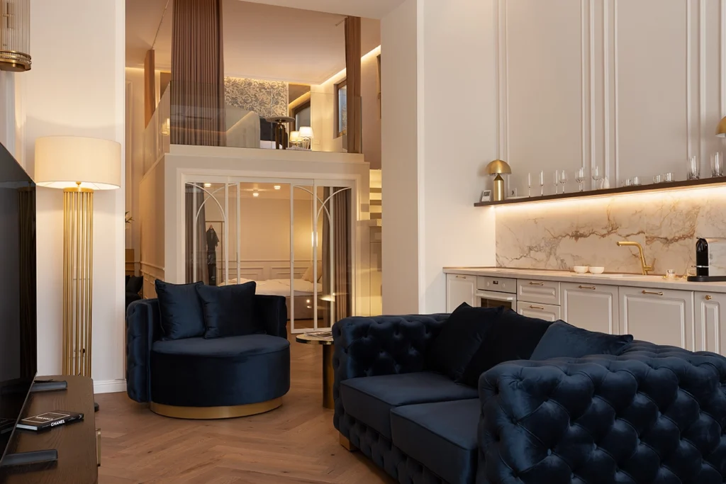 Modern living room with navy velvet sofas from MA Furniture, marble kitchen backsplash from Zaya and loft-style bedroom.