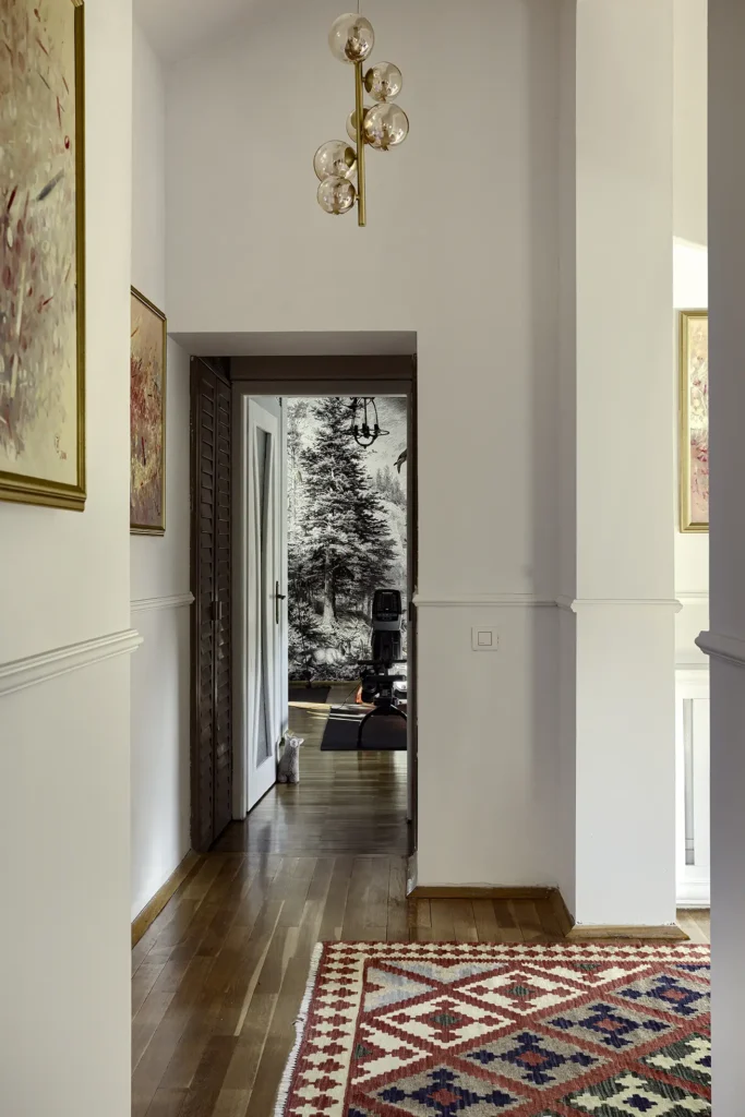 Luxury hallway interior with kilim rug, wooden floor and contemporary chandelier, photographed for architectural and interior design inspiration.